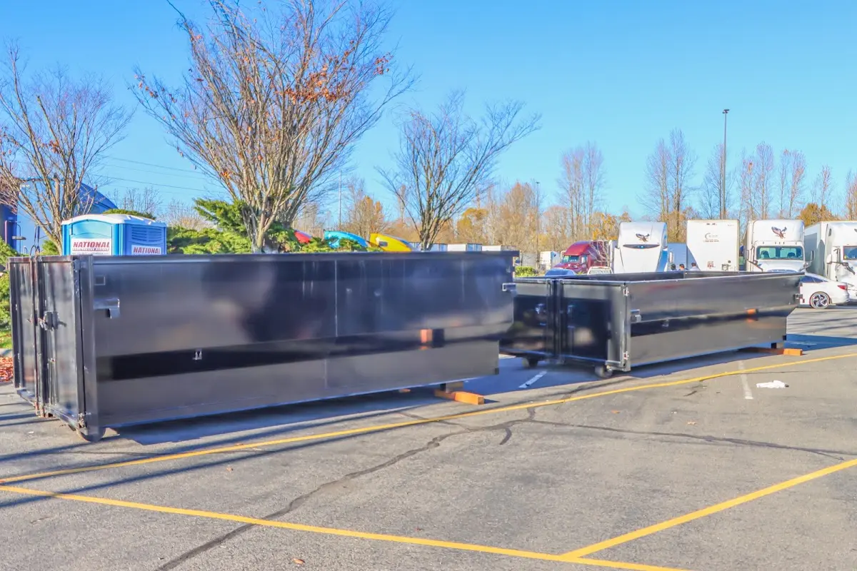 Professional dumpster rental service with roll-off container on residential driveway in Dakota Dunes